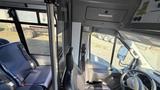 A 2021 Ford Transit interior showing two seats, a steering wheel, and the dashboard with controls visible