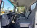 Interior view of a 2022 Isuzu NQR showing the driver's side with a steering wheel and two seats in gray fabric upholstery
