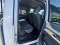 Interior view of a 2016 Ford F-350 SD showing the rear seating area with gray fabric seats and the passenger side door open