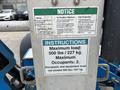 Control panel of a 2016 Genie TZ-34/20 featuring safety notices load limits and instructions for operation
