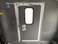 A 2014 Ford E-350 wheelchair-accessible bus door with a handle and a small window