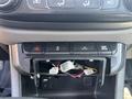 A 2017 Chevrolet Colorado's center console with an open storage area showing wires and connectors inside.