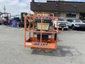 A 2009 JLG E300AJP aerial lift with an orange cage and control panel prominently displayed in the foreground