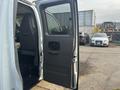 A 2021 Chevrolet Express van with the driver's side door open showing the interior and seating area