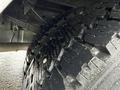 Close-up of a heavily treaded tire from a 2000 Ford F-450 showing deep grooves and a robust design suitable for heavy-duty use