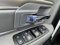 Close-up of a modern vehicle door handle and window control panel featuring buttons for window adjustments and a lock interface
