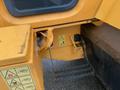 A close-up view of a yellow 2016 Hyundai HL940 loader with safety warning labels and a footstep for access