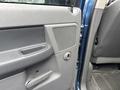 The interior door panel of a 2006 Dodge Ram 2500 featuring a speaker grille door handle and window controls