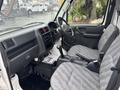 Interior of a 2010 Suzuki Carry showing seats steering wheel dashboard and gear shift with gray upholstery and black accents