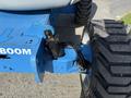 Close-up of a blue Genie Z 45/25 aerial work platform's boom and wheel showing hydraulic components and tire tread detail