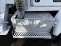 A silver metallic step and exhaust stack of a 2008 Kenworth T370 with a textured surface design and perforated sections