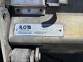 A metal label attached to machinery displaying the name ROM Corporation along with an address in Belton Missouri and a serial number
