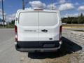 A white 2017 Ford Transit van viewed from the rear with the model name visible on the back door