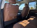 A 2015 RAM 1500 with leather seating in a brown color featuring a rear seating area and armrest compartments