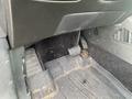 A close-up view of the footwell in a 2017 Ford Edge showing the gas and brake pedals with dirt and debris on the floor mat