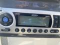 A Jensen JMS2012 stereo displaying a blank screen with various control buttons including volume and seek options