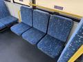 Three blue upholstered bus seats with a geometric pattern arranged in a row