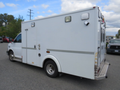A 2011 Chevrolet Express designed as an ambulance with a white exterior and emergency lighting features on the roof and rear doors