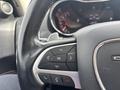 Steering wheel of a 2015 Dodge Durango with control buttons for phone and audio to the left and a central OK button
