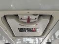 A ceiling-mounted emergency exit hatch with a red handle labeled in English and French indicating how to open it