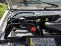 The image shows the engine compartment of a 2008 Ford Econoline with various components including the battery hoses and fluid reservoirs