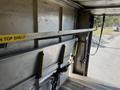 Interior of a 2012 Ford Econoline cargo van showing an empty metal shelving unit with yellow markings and straps for securing cargo