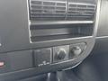 Close-up of the dashboard controls in a 2022 GMC Savana featuring air vents and various knobs and switches for ventilation and power outlets