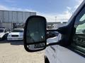A side mirror of a 2012 Ford Econoline E-450 reflecting a surrounding parking lot and vehicles