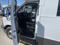 A 2020 Chevrolet Express van with the driver's door open revealing the interior and driver's seat