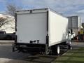 A white 2014 International TerraStar box truck with a blank rear door and a hitch at the back parked on a lot
