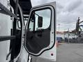 The image shows the open driver's door of a 2021 Freightliner M2 106 revealing the interior panel and side mirror