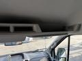 Interior view of a 2016 Ford Transit 150 showing the dashboard and overhead compartments