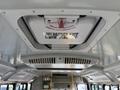 Ceiling of a 2017 Chevrolet Express showing an emergency exit sign and a ventilation system with a latch mechanism