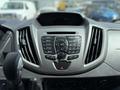 Dashboard of a 2018 Ford Transit with controls for radio media phone and sound alongside air conditioning vents and a gear shift