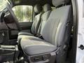Interior view of a 2015 Ford F-550 showing gray fabric seats in the front cab with a focus on the driver's side seat and steering wheel