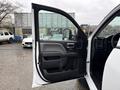 A 2015 GMC Sierra 1500 with the driver's side door open showing the interior door panel and controls