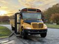 A 2014 International 4300 school bus with a yellow and black exterior positioned at an angle with the door open