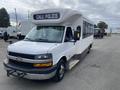 A 2020 Chevrolet Express bus with a white exterior and a black front grille featuring a Chevrolet emblem displaying a sign that reads CALL POLICE on the destination board