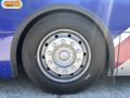 Close-up of a metallic bus wheel with a shiny rim and a black tire, featuring visible lug nuts and the brand name printed on the sidewall