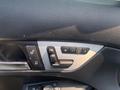 A close-up view of the driver's side door panel in a 2013 Mercedes-Benz C-Class featuring window controls and seat adjustment buttons
