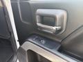 Interior door handle and control panel of a 2017 Chevrolet Silverado 1500 featuring a chrome handle and window adjustment button