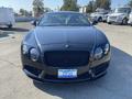 A black 2015 Bentley Continental GT with a distinctive front grille and sleek design focused on the vehicle's front view