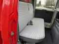 Interior view of a red 2001 Toyota Dyna featuring a long bench seat with patterned upholstery and seatbelt