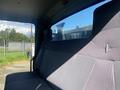 The interior of a 2014 International 7400 showing a gray bench seat with a textured pattern and a large window behind it providing a view of the outside