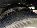Close-up of two large, rugged tires designed for a 2024 RAM 5500 with deep treads showcasing water splashes on the surface