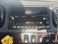 The dashboard of a 2022 Freightliner M2 106 featuring a radio unit with Bluetooth capabilities and various control buttons for audio settings and navigation