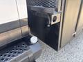 Close-up of the rear compartment and hitch area of a 2005 GMC C7500 Topkick showing the connection point and part of the storage unit door