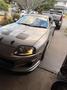 A silver 1997 Toyota Supra with a streamlined body and distinctive front headlights is parked in a driveway