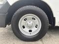 A close-up of a silver wheel rim with five lugs mounted on a large black tire designed for a 2016 RAM 1500 vehicle