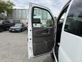 A 2004 Chevrolet Express with the driver's side door open revealing the interior features and door panel design